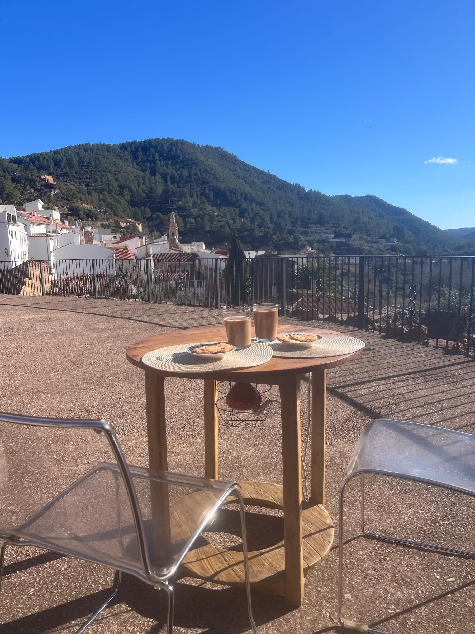 Desayuno servido en la terraza con vistas al valle, junto a la casa, con el campanario al fondo